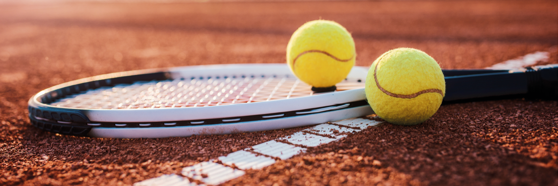 Tennisschläger und Tennisbälle am Boden